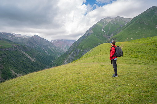 Young boy sitting and meditating in the mountains of Kazbegi Georgia.