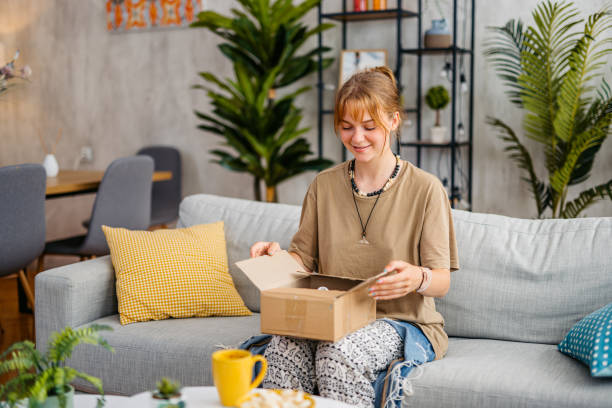 istock Young Woman Unboxing A Package At Her Apartment 1603485522