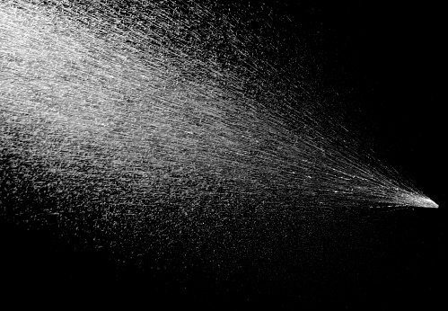 Water spray stream isolated on black background.