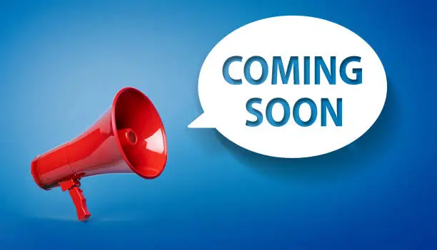 Coming Soon written speech bubble and red megaphone on blue background
