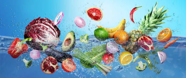 istock Many fruits and vegetables falling into water against blue background 1603491950