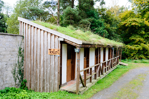 Outdoor composting toilet block with ecological grass roof.