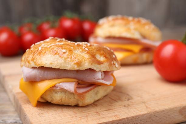 istock Delicious bagels with ham and cheese on table, closeup. Space for text 1603516226