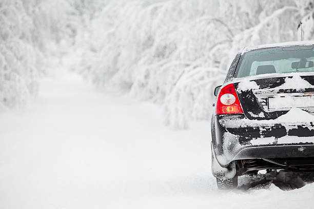 ブラックの陸上車の上に立つ冬 road - rear view winter blizzard nordic countries ストックフォトと画像