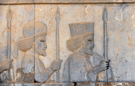 Ancient wall with bas-relief with two assyrian warriors with spears, Persepolis, Iran. UNESCO world heritage site