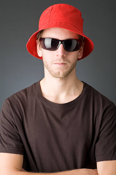 Studio photograph of young bearded man wearing leather jacket,hat and sunglasses. Copy space.