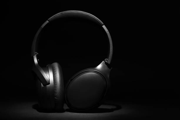 istock Modern wireless headphones on black background, space for text 1603551190