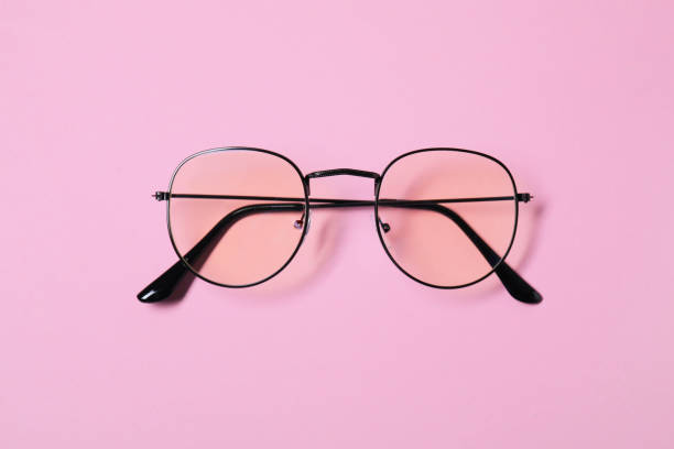 istock Stylish pair of glasses with black frame on pink background, top view 1603551744