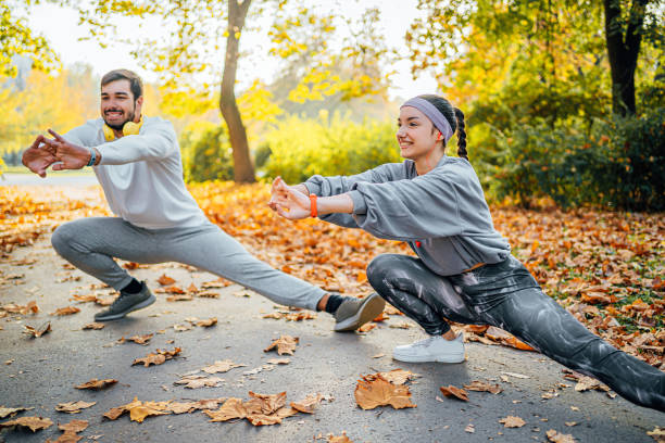 istock Young couple doing stretching exercises in the park 1603556066