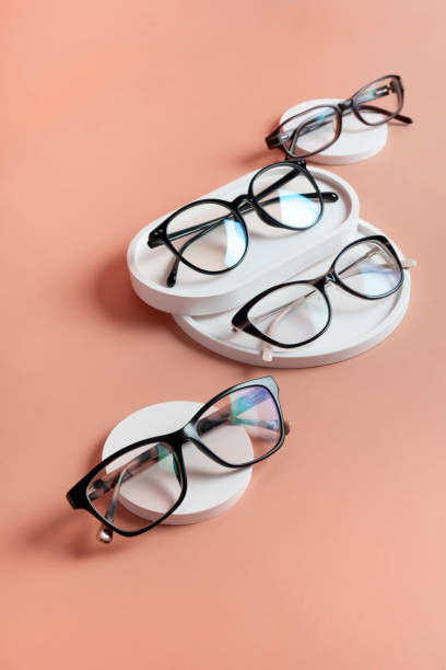 Podiums with eyeglasses on colored background. Optical store, vision test, stylish glasses concept top view, flat lay