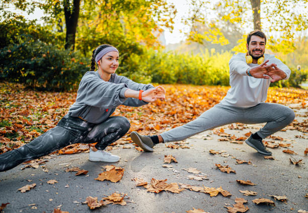 istock Young couple doing stretching exercises in the park 1603558285