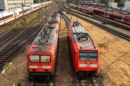 Two electric locomotives. Frankfurt Germany - July 19, 2023: Train locomotives on the siding. Signaling systems, railroad ties and switches. ICE train on the left side.