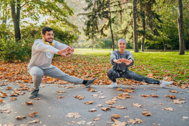 istock Young couple doing stretching exercises in the park 1603566319