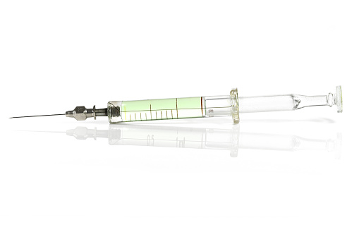 glass syringe filled with green liquid isolated on white background