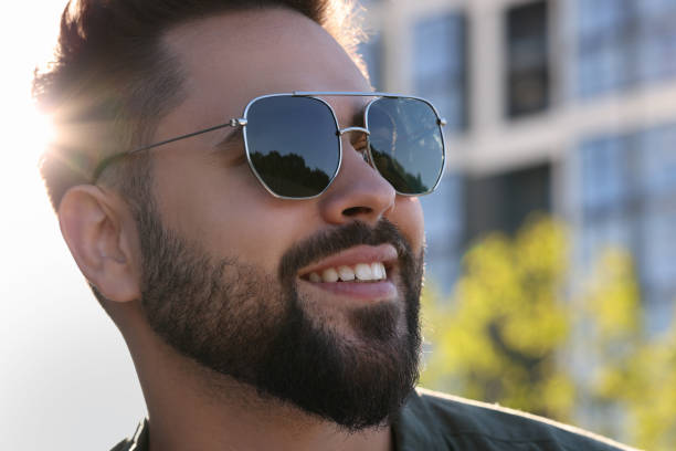 istock Handsome smiling man in sunglasses outdoors, closeup. Space for text 1603593048