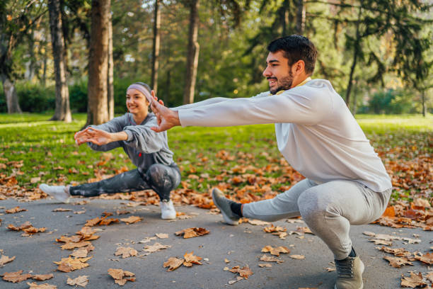 istock Young couple doing stretching exercises in the park 1603598592