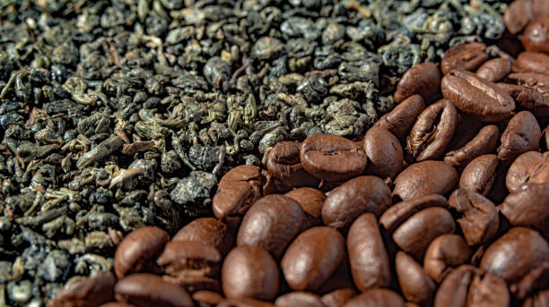 istock coffee beans and green tea are laid out in two strips, creating a diagonal border between them. Close-up. Selective focus 1603624617