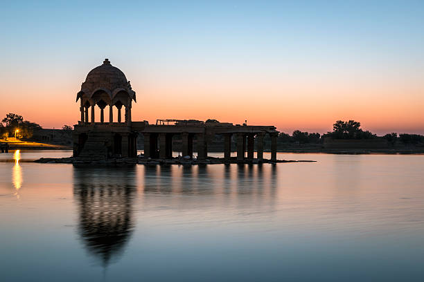 Stone tower in sacred Gadi Sagar lake, Jaisalmer, India Stone tower in sacred Gadi Sagar lake in Jaisalmer, India during sunrise jaisalmer stock pictures, royalty-free photos & images