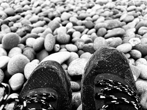 Hiking boots against pebbles on a beach
