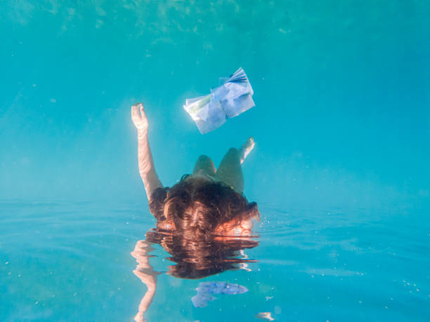 istock Little girl reading a book while under sea 1603665157