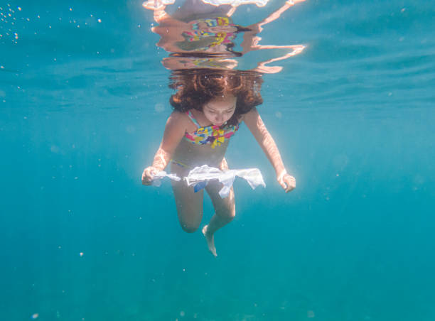istock Little girl reading a book while under sea 1603665688