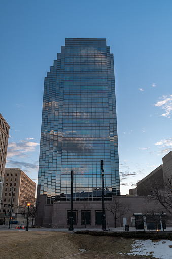 Denver, Colorado - February 12 2023: A view of the mirrored reflection of a downtown highrise in the moments before the sun rises in the eastern sky and before the city wakes up.