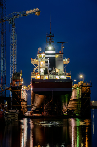 general cargo vessel in floating dock for maintenance at night