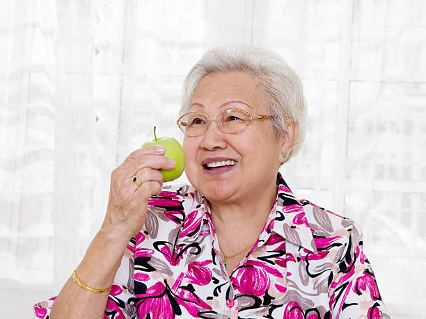istock asian senior woman eating an apple 160370929