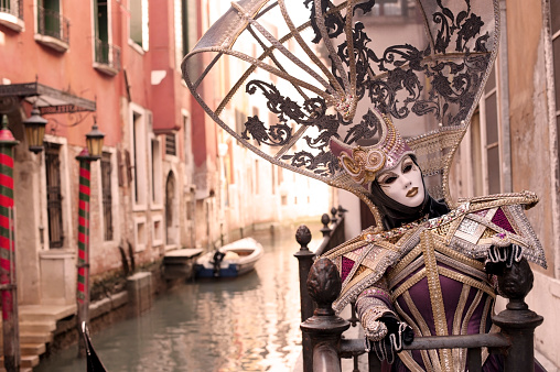 Venice, VE, Italy - February 13, 2024: two people with white masks on the seashore