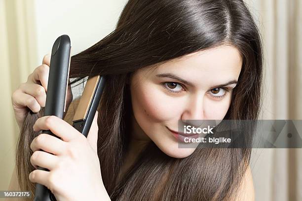 Young Sultry Woman Straightening Her Hair Stock Photo - Download Image Now - Domestic Bathroom, Straight Hair, White People