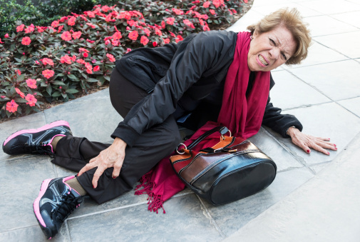 Senior woman lying on floor after falling feeling pain in her leg