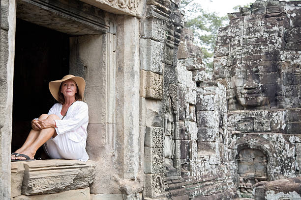 Young man traveling in Cambodia visiting the temples of Angkor wat complex. People travel discovery Asia concept. Shot at sunset, one man only, adventure and exploration in Siem Reap, Southeast Asia.