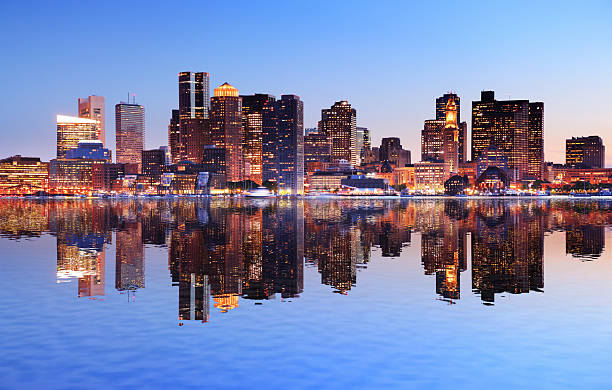 la ville de boston avec reflet dans l'eau au coucher du soleil - boston skyline night city photos et images de collection