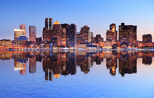 Boston City with Water Reflection at Sunset Boston City with Water Reflection at Sunset boston skyline night skyscraper stock pictures, royalty-free photos & images