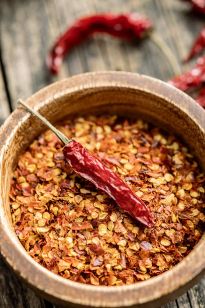istock Crushed and whole chili peppers in bowl. 1603750435