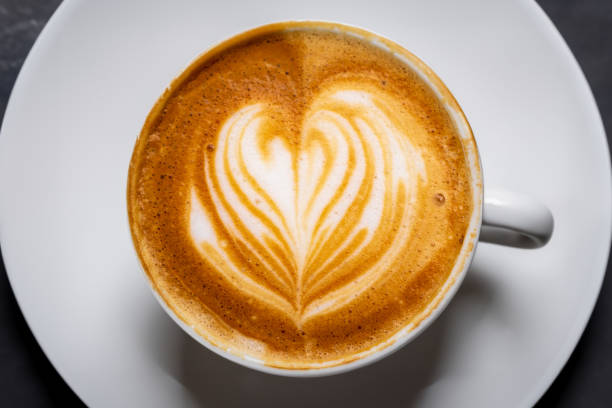 vue de dessus d’une tasse de cappuccino au café chaud isolée sur fond noir - koffie photos et images de collection