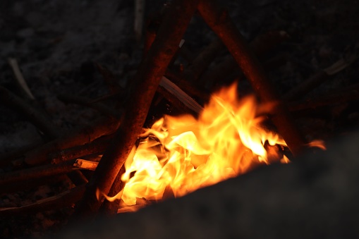 A scenic view of a campfire with glowing yellow flames