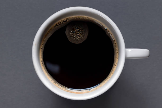 une tasse de café noir sur fond gris. vue d’en haut - koffie photos et images de collection
