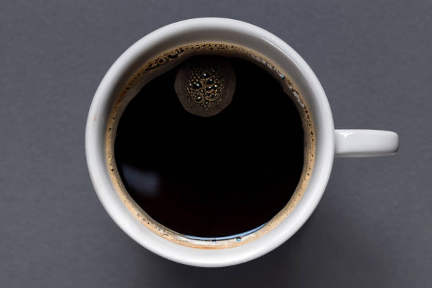 een kopje zwarte koffie op grijze achtergrond. van bovenaf bekijken - coffee cup isolated cappuccino multi colored imagens e fotografias de stock