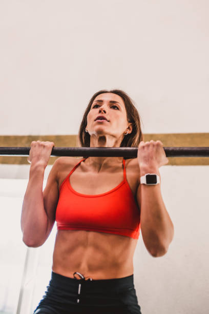 istock Pulling on the horizontal bar young strong girl 1603796789