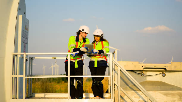 inżynier pracujący z pewnością siebie. pracownik pracujący na zewnątrz. mega budowa projektu. - alternative energy electricity wind turbine team zdjęcia i obrazy z banku zdjęć