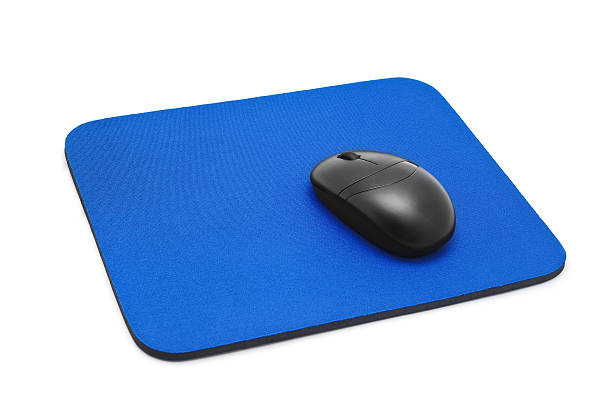 Black computer mouse resting on bright blue mousepad stock photo