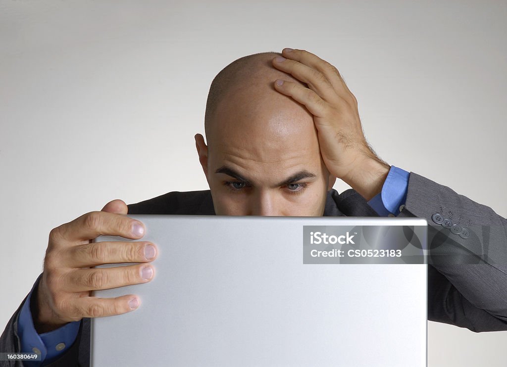 A bald man struggling to figure out a network error Worry businessman working on computer Adult Stock Photo