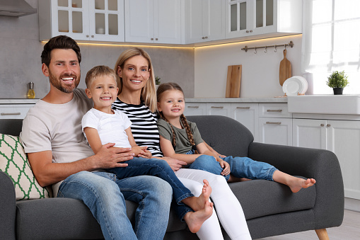 Portrait of happy family with children on sofa at home