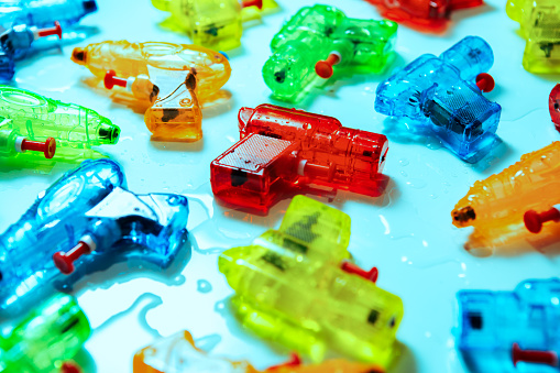 Summer fun in multi-colored plastic water guns, ready to help cool off in the heat of the sun.