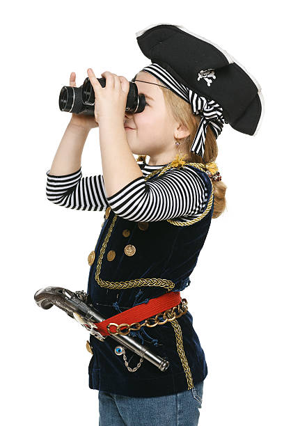 маленькая девочка в костюм из пиратский отвести взгляд через бинокль - little girls pre adolescent child standing isolated стоковые фото и изображения