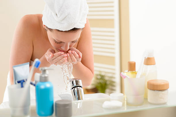 istock Woman washing face above bathroom sink 160385984