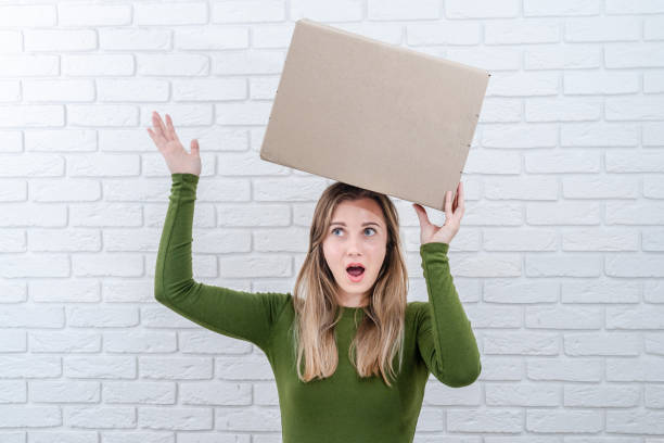 istock Attractive woman with parcel box on her head. Delivering a parcel 1603889722