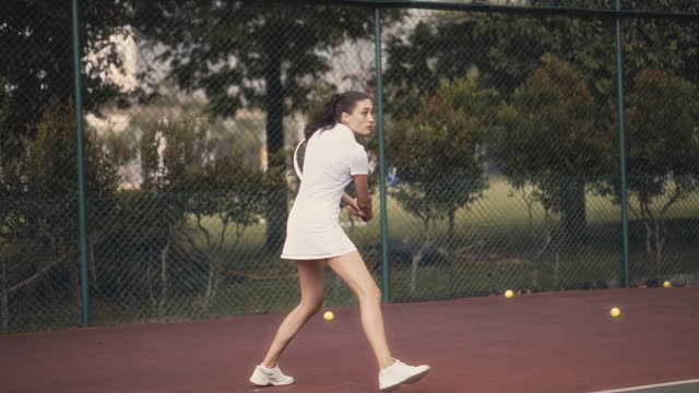 One teenage girl tennis player practicing playing in tennis court