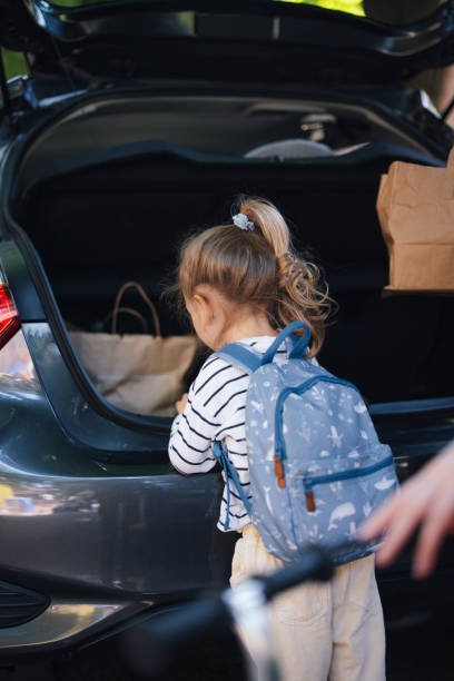 istock Anonymous Little Girl Putting Things in the Car Boot 1603909450